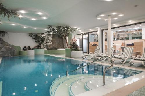 uma grande piscina com cadeiras num hotel em Hotel Zum Mohren em Resia