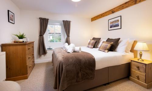 a bedroom with a large bed and a window at Yew Tree Cottage Borrowdale in Rosthwaite