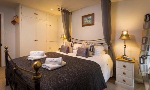 a bedroom with a large bed with pillows on it at Burrow Cottage in Bowness-on-Windermere