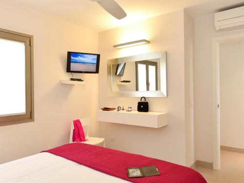 a bedroom with a bed and a tv on the wall at San Agustin Beach Apartments in San Agustin