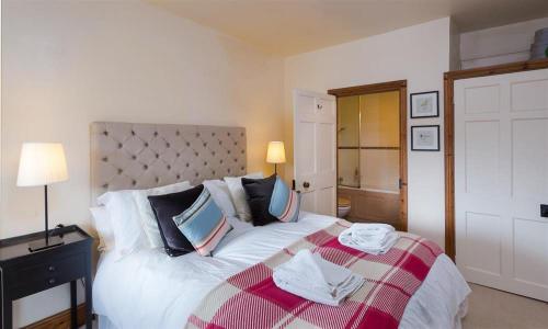 a bedroom with a large bed with a red and white blanket at Riverbank At Stepping Stones in Ambleside