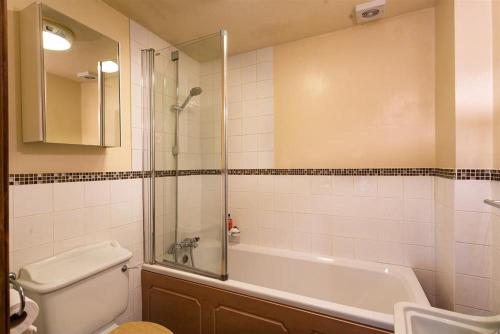 y baño con bañera, aseo y lavamanos. en Riverbank At Stepping Stones, en Ambleside