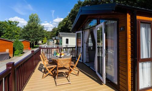 a deck with a table and chairs on a house at Lancashire Rose in Windermere