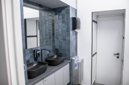 a bathroom with two sinks and a mirror at AV-2 capsule hotel in Kyiv