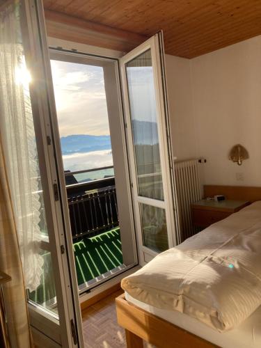 a bedroom with a bed and a balcony with a view at Landgasthof Krone Bed & Breakfast in Sankt Gallenkappel