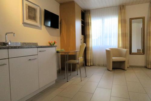 a kitchen with a counter and a table and chairs at Landgasthof Krone Bed & Breakfast in Sankt Gallenkappel