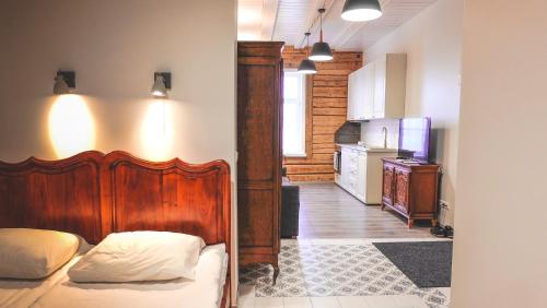 1 dormitorio con cama de madera y cocina en Õhtu Apartments en Haapsalu
