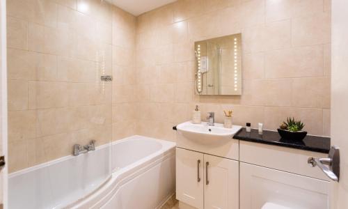 La salle de bains est pourvue d'une baignoire blanche et d'un lavabo. dans l'établissement Lakeland Loft, à Windermere