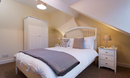 a bedroom with a large bed with a wooden headboard at Noble Cottage in Keswick