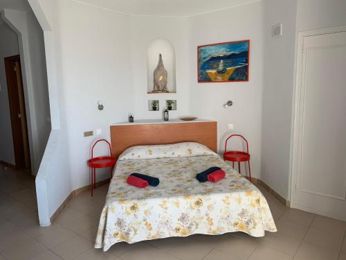 een slaapkamer met een bed en twee rode stoelen bij Welcome to Paradise in Adeje