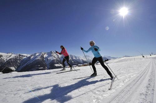 two people are skiing on a snow covered mountain at Carpe Diem 2 in Fiesch