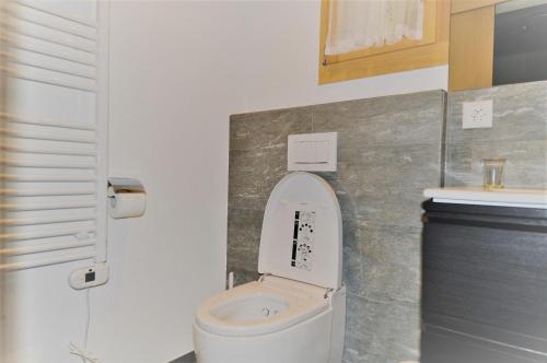 a bathroom with a white toilet and a sink at Carpe Diem 2 in Fiesch