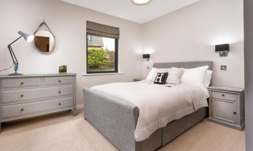 a bedroom with a bed and a dresser and a window at Foxrock in Windermere