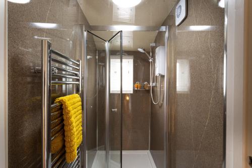 a shower with a glass door in a bathroom at Dovedale in Keswick