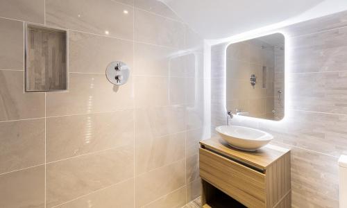 La salle de bains est pourvue d'un lavabo et d'un miroir. dans l'établissement Cragfell Cottage, à Cartmel