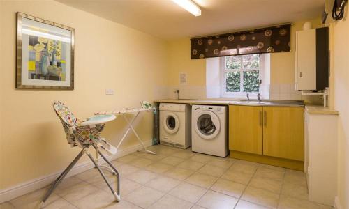 a kitchen with a washing machine and a sink at Woodside West in Bowness-on-Windermere