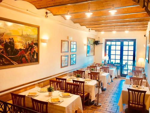 a restaurant with tables and chairs and a painting on the wall at Hotel Ristorante Garibaldi in Frosinone