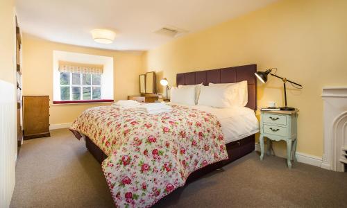 een slaapkamer met een groot bed met een sprei met bloemen bij South Stonethwaite Cottage in Windermere