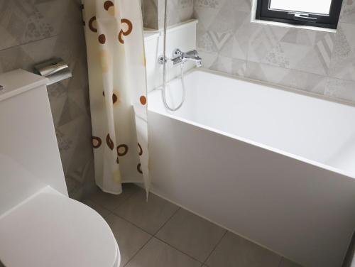a bathroom with a white tub and a toilet at City Inn Macau in Macau