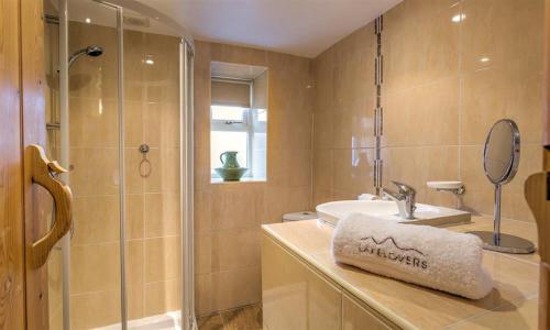 une salle de bains avec douche, lavabo et miroir dans l'établissement Mulberry Cottage, à Kendal