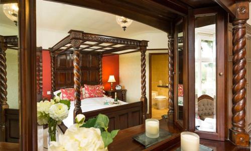 アンブルサイドにあるBracken Howeのベッドルーム1室(天蓋付きベッド1台、テーブル、キャンドル付)