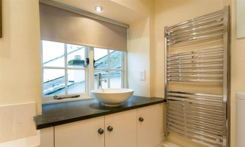 a bathroom with a bowl sink and a window at Ivy Cottage in Ambleside