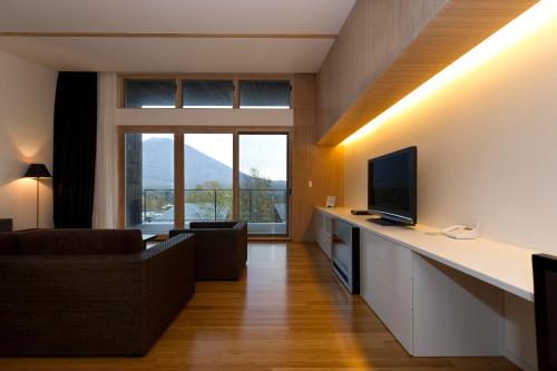 a living room with a couch and a television at Forest Estate in Kutchan