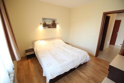 a bedroom with a white bed in a room at Guest House Ela in Bansko