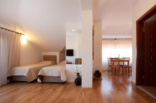 a bedroom with a bed and a dining room with a table at Guest House Ela in Bansko