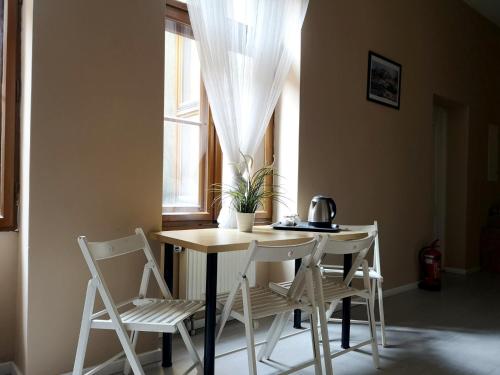 stół i krzesła w pokoju z oknem w obiekcie Rynek 7 w mieście Katowice