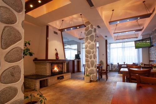 a lobby with a fireplace and a table and chairs at Guest House Ela in Bansko