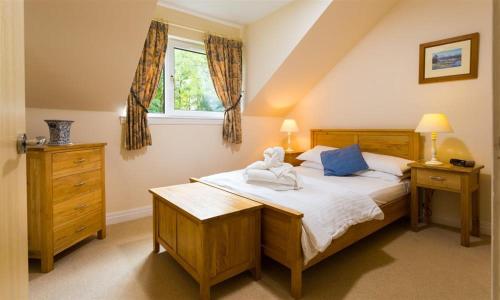 a bedroom with a large bed and a window at Troutbeck - Whitbarrow Village in Penrith