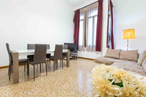 a living room with a table and chairs and a couch at CA CICOGNA air conditioning and fast WiFi, central location apartment in Venice