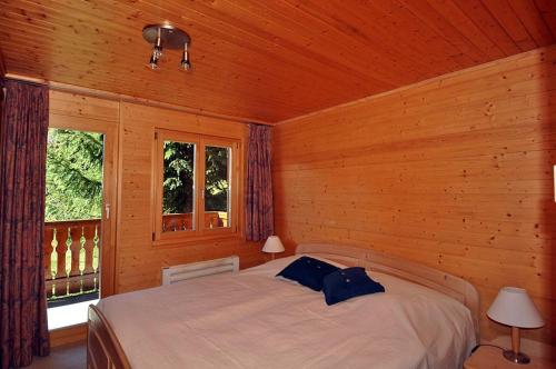 - une chambre avec un lit dans une pièce en bois dans l'établissement Harpa OG, à Bettmeralp