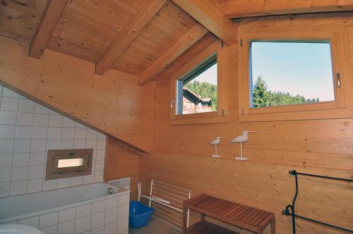 - une salle de bains en bois avec un banc et une fenêtre dans l'établissement Harpa OG, à Bettmeralp