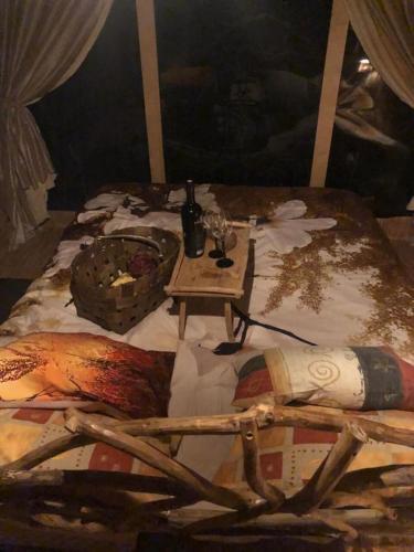 a painting of a bed with a table with aoodoo at Bebru māja - Beaver house in Usma