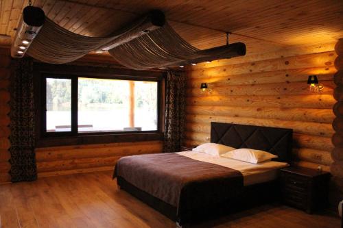 a bedroom with a bed in a log cabin at Charivne Ozero in Korostyshiv