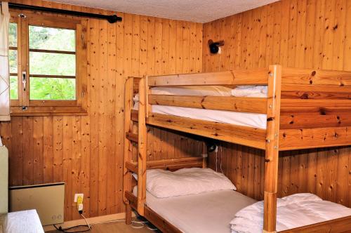 two bunk beds in a room with wooden walls at Melchior in Fiesch