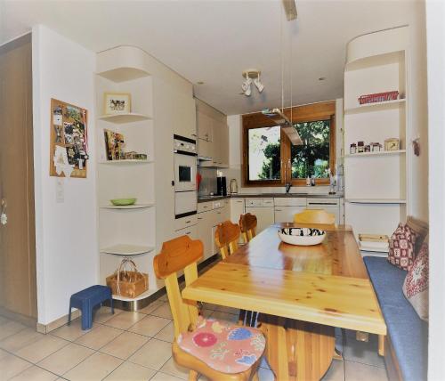 a kitchen and dining room with a wooden table and chairs at Aleid Sunshine in Fiesch