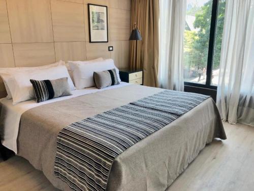 a large bed in a bedroom with a large window at RQ Santa Magdalena in Santiago