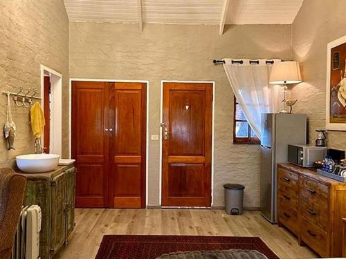 baño con puertas de madera, fregadero y nevera en Lakeside Chalets Critchley Hackle Lodge, en Dullstroom