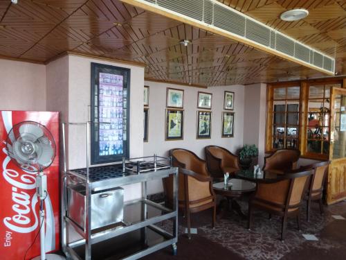 a restaurant with a coca cola machine and chairs at Hotel Combermere in Shimla