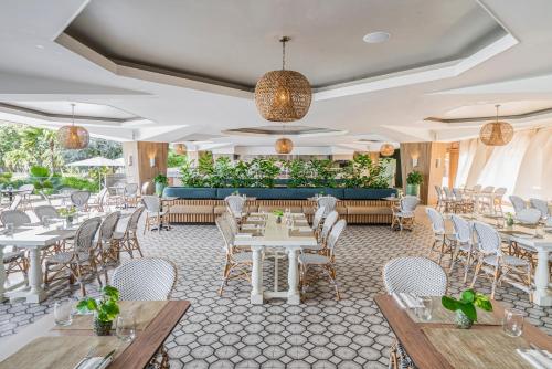 a restaurant with white tables and chairs at Dreams Curacao Resort, Spa & Casino in Willemstad