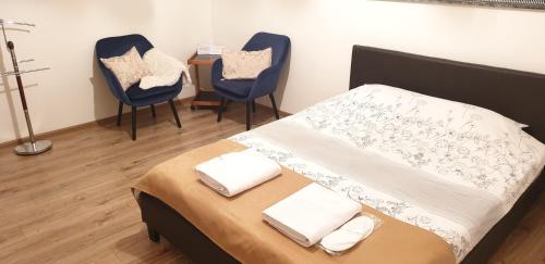 ブラショヴにあるCentral Apartment DumDix Brasovのベッドルーム1室(椅子2脚、ベッド1台、テーブル付)