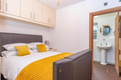 - une chambre avec un lit doté d'oreillers jaunes et d'un lavabo dans l'établissement The Shed, à Coventry