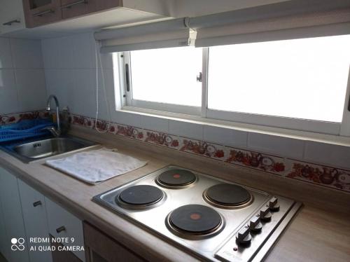 cocina con fogones, fregadero y ventana en Departamento La Serena, en La Serena