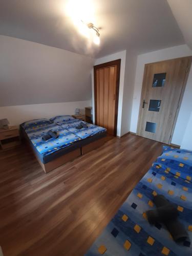 a bedroom with a bed and a wooden floor at Andrea- neakceptujeme mladé partie in Terchová