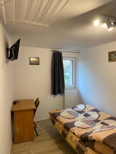 1 dormitorio con cama, escritorio y ventana en Pokoje na wynajem Sopot, en Sopot