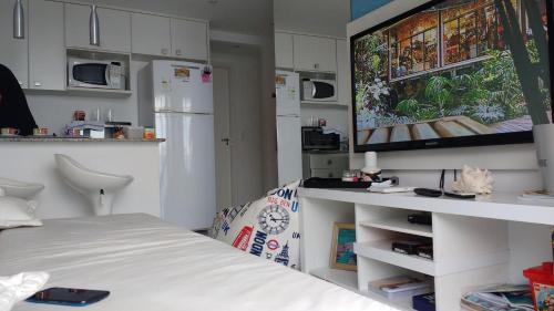 Mangaratiba Porto Real Suíte في مانغاراتيبا: غرفة نوم بسرير وتلفزيون بشاشة مسطحة