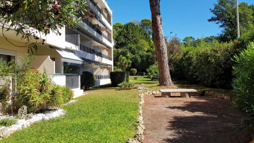 un jardín con un banco junto a un edificio en CANNES STUDIO - 4 personnes, en Cannes